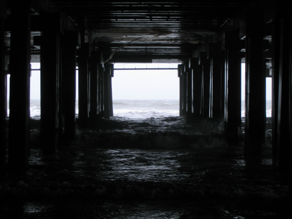 Photograph of waves crashing in under the boardwalk in Atlantic City, New Jersey